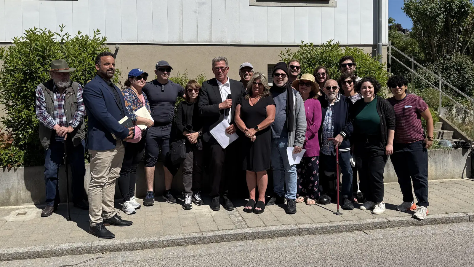 Dieter Springmann und Silke Leisering (Mitte) inmitten der Nachkommen einst vertriebener Juden, deren Wurzeln in Ermetzhofen liegen. Vor dem Haus 104, in dem die Familie Grünhut bis zum 9. November 1938 lebte, wurden drei Stolpersteine symbolträchtig verlegt. Ganz links steht Peter Neumann von der evangelischen Kirchengemeinde. (Foto: Sylvia Fehlinger)