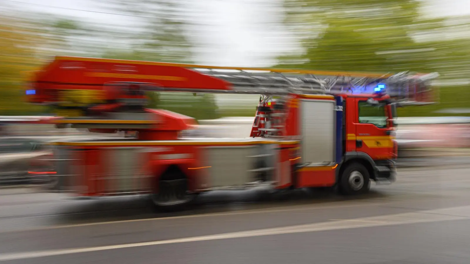 Ein Feuerwehrfahrzeug mit Drehleiter fährt zu einem Einsatz. (Foto: Robert Michael/dpa)