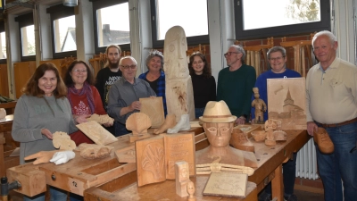 Ein Hut und eine Büste, eine filigran gearbeitete Kirche, Hände, Füße, die stelenartige Noris aus Pappel und viel Figürliches mehr. Jung und Alt lernen bei Wolfgang Hille (Dritter von rechts) das Schnitzen. (Foto: Anita Dlugoß)