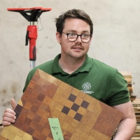 Parkettlegermeister und Restaurator Lars Wildermann aus Hohlach zeigt eine der unzähligen Parketttafeln, die auf die Restaurierung warten. (Foto: Constantin Prosch)