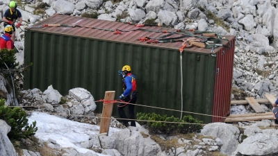 Einsatzkräfte stehen am Untersberg am Einstieg der Riesending-Schachthöhle bei einem Container. (Foto: Tobias Hase/dpa/Archivbild)