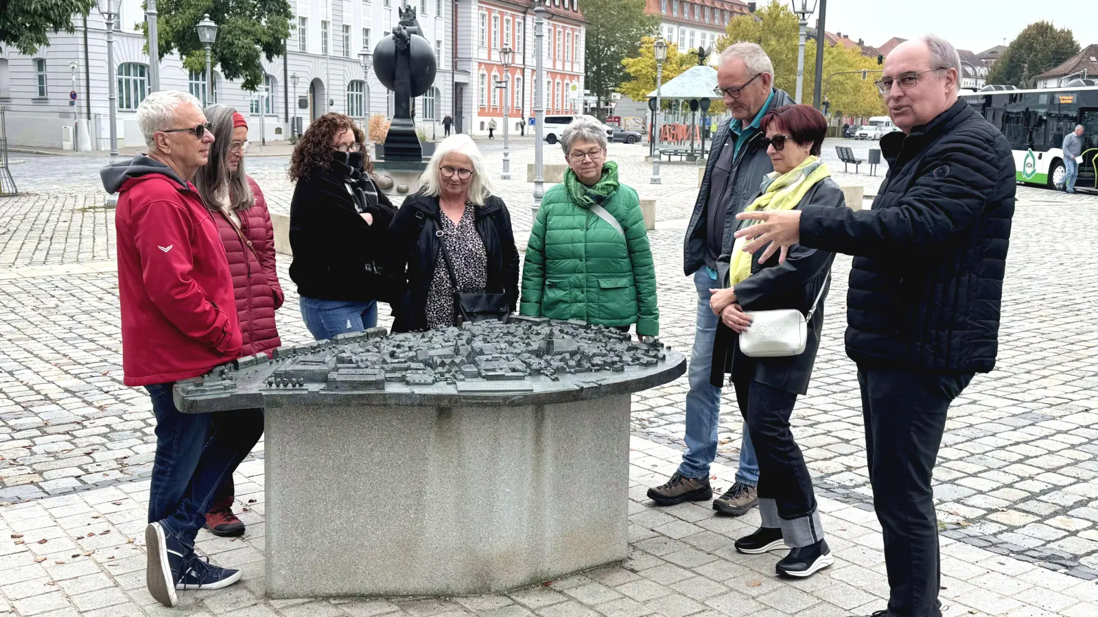 Stadtführer Alexander Biernoth (rechts) erläutert einer Gruppe das Bronzemodell auf dem Schloßplatz. (Foto: Oliver Herbst)