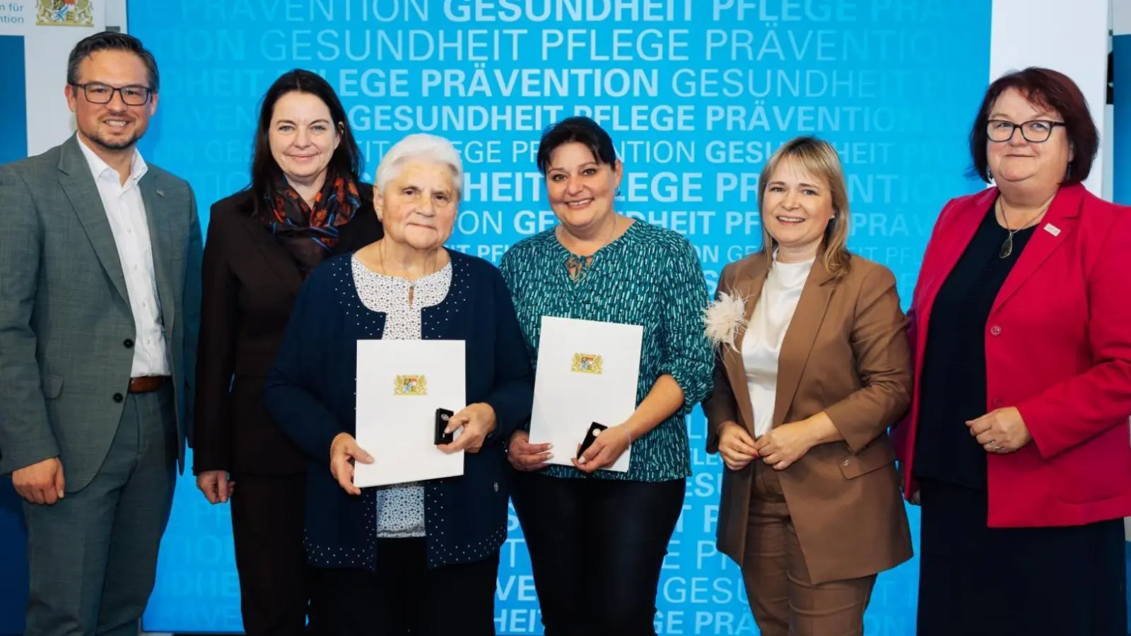 Margareta Reiß und Silvia Heubeck (mit Urkunden) wurden von Regierungspräsidentin Dr. Kerstin Engelhardt-Blum (Zweite von links) geehrt. Zu den Gratulanten zählen auch Landtagsgeordneter Werner Stieglitz, Neuhofs Bügermeistern Claudia Wust und stellvertretende Landrätin Ruth Halbritter (rechts). (Foto: Bayerisches Staatsministerium für Gesundheit, Pflege und Prävention)