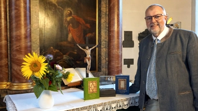 Zwei Teile der Fränggischn Bibl sind fertig. Stolz präsentiert der Lichtenauer Pfarrer Claus Ebeling die Werke vor dem Altar der Dreieinigkeitskirche. (Foto: Andrea Walke)