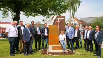 Ein Denkmal soll an die Dorferneuerung erinnern. Gemeinsam enthüllten es die „Offiziellen“ am Sinbronner Dorfplatz. (Foto: Martina Haas)