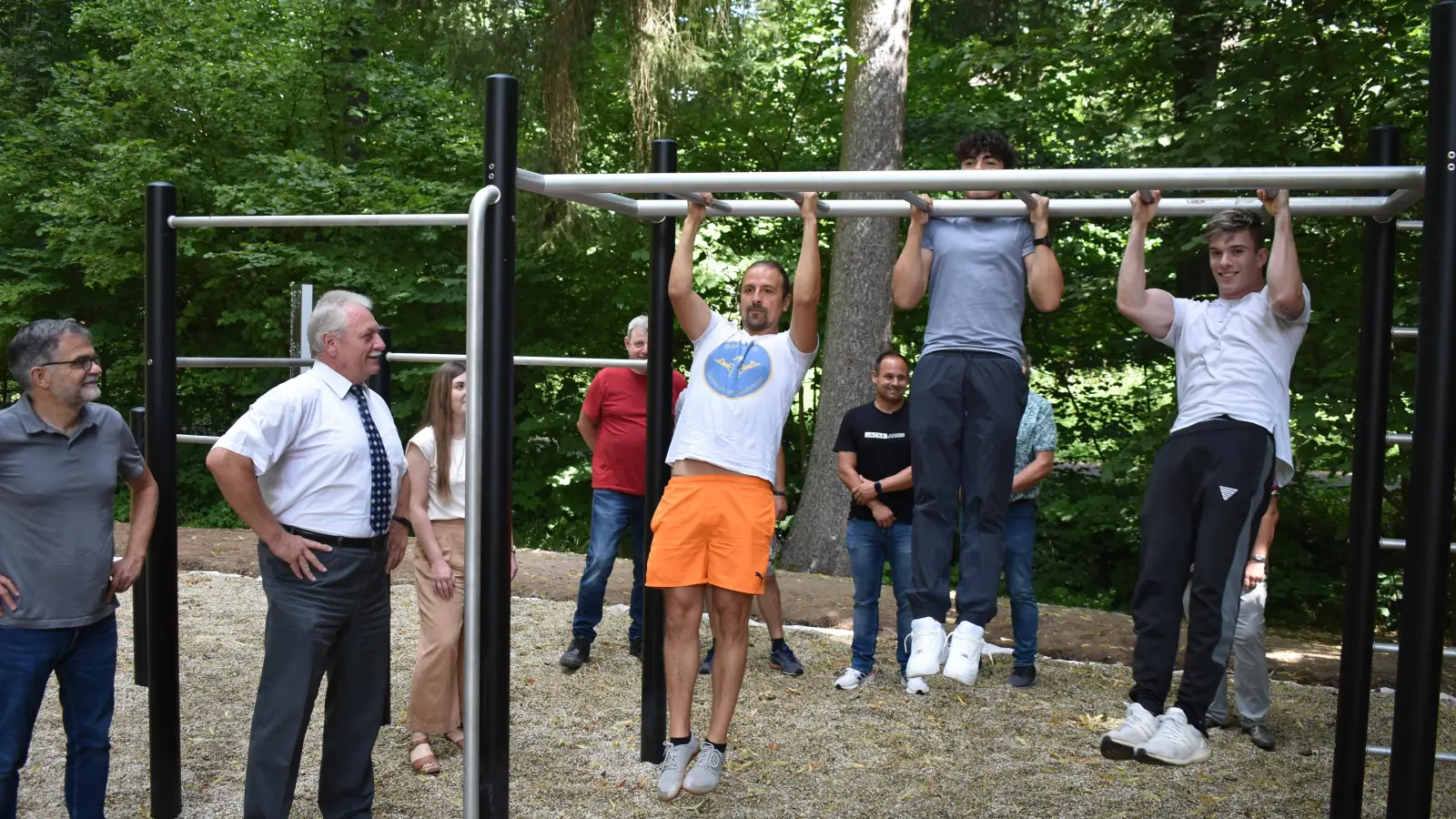 Anlässlich der Einweihung des neuen Calisthenics-Fitness-Park im Stadtpark zeigten Dieter Werner, Mahmoud Ali und Lukas Selig einige Übungen. Die anderen Anwesenden beließen es beim Zuschauen. (Foto: Ute Niephaus)