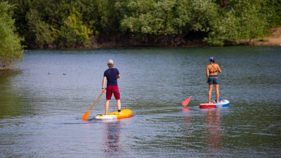 Das Stehen auf einem SUP-Board fordert Muskeln in Rumpf, Beinen und Füßen. (Foto: Thomas Banneyer/dpa/dpa-tmn)
