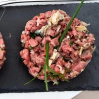 Bei Jérôme Meuniers Vorspeise „Land und Meer“ trifft die fleischige Würze des Rinds auf die jodige Frische der Austern.  Das Beef wird für das Tatar nicht durch den Wolf gedreht, sondern fein gewürfelt.  (Foto: Andreas Drouve/dpa-tmn)