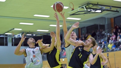 David Kurpiela (im weißen Trikot in der Mitte) kämpft hier gegen die Münchner Pirmin Gaisser (links daneben) und Daniel Urbano (rechts) um den Rebound, links lauert sein Ansbacher Teamkollege Paul Nzeocha. Gegen Vilsbiburg werden beide wieder unter den Körben gefordert sein. (Foto: Martin Rügner)