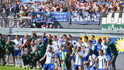 Zusammen mit den Fans feiern die Schalker in Paderborn. (Foto: Swen Pförtner/dpa)