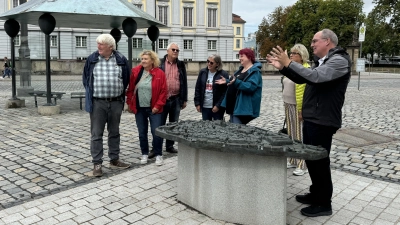 Die erste Station dieser öffentlichen Stadtführung mit dem Historiker Alexander Biernoth (rechts) bildete das Bronze-Tastmodell des Zentrums auf dem Schlossplatz gegenüber der Residenz. (Foto: Oliver Herbst)