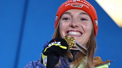 Katharina Althaus präsentiert und ihre WM-Goldmedaille. (Foto: Daniel Karmann/dpa)