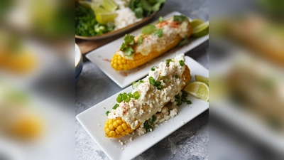 Die fertigen Maiskolben bekommen ein „Zudecke“ aus selbstgemachter Mayo und Dingen, die der Kühlschrank gerade so hergibt - etwa Parmesan, Feta, Frühlingszwiebel und Rucola. (Foto: Mareike Pucka/biskuitwerkstatt.de/dpa-tmn)