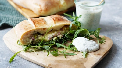 Das Handbrot mit der Füllung aus Schinken, Gouda und Frühlingszwiebeln schmeckt nicht nur, sondern weckt auch Festival-Erinnerungen. (Foto: Mareike Pucka/biskuitwerkstatt.de/dpa-tmn)
