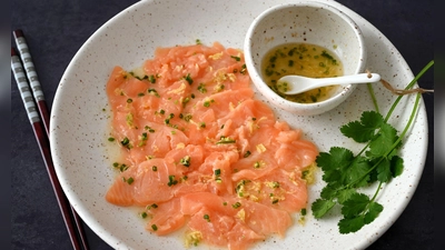 Wenn man das Lachs-Carpaccio mit dem asiatischen Dressing beträufelt, wird die Farbe des Fischs etwas heller. (Foto: Julia Uehren/loeffelgenuss.de/dpa-tmn)