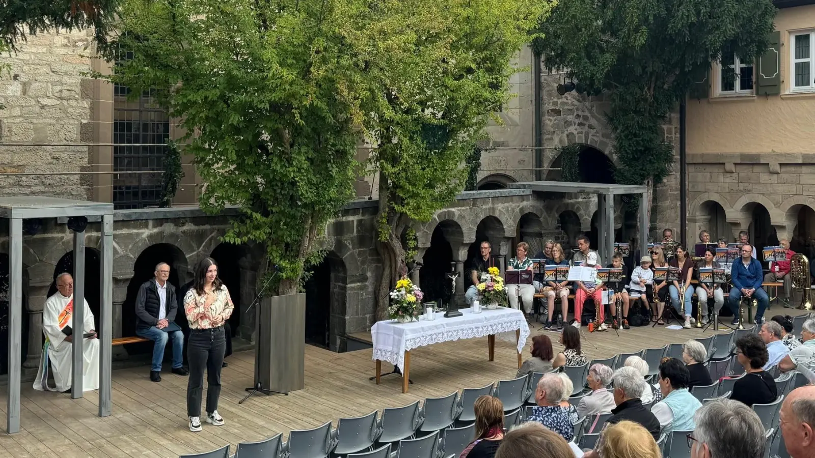 Einen Monolog aus Friedrich Dürrenmatts Stück „Der Besuch der alten Dame“ trug Kirsten Schneider (Dritte von links) beim Theater-Gottesdienst im Kreuzgang vor. In der Feuchtwanger Inszenierung ist die Schauspielerin in der Rolle der Pfarrerin zu sehen. (Foto: Kreuzgangspiele/Dr. Maria Wüstenhagen)