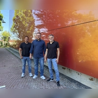 Bunt und spiegelnd ist die neue Fassade der Markgrafenhalle. Über den gelungenen Abschluss des vorletzten Bauabschnittes freuen sich (von links): Bauamtsmitarbeiter Frank Maes, Bürgermeister Alexander Müller und Bauamtsleiter Gerald Schorr. (Foto: Nicole Gunkel)