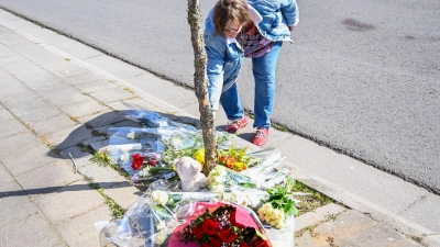 Eine Frau im belgischen La Louviere legt Blumen an der Unfallstelle nieder, wo ein angetrunkener Autofahrer bei einer Karnevalsveranstaltung in eine Menschengruppe gefahren ist. Sechs Menschen starben, zehn waren am Montag noch in kritischem Zustand. (Foto: Laurie Dieffembacq/BELGA/dpa)