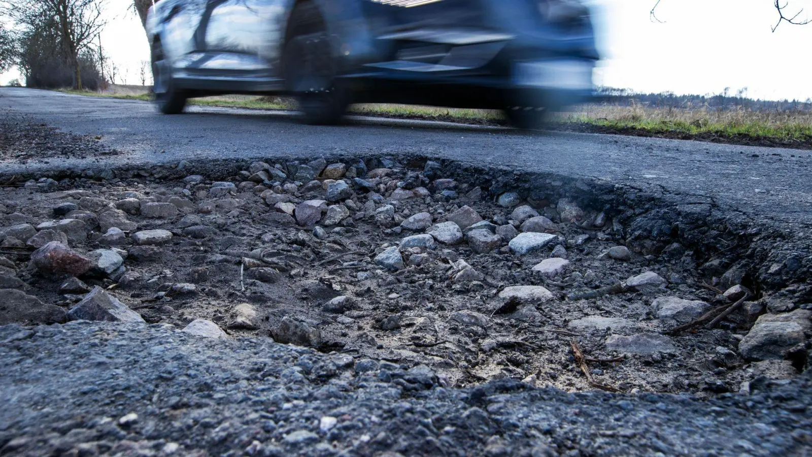 Wer mit hohem Tempo durch ein Schlagloch fährt, riskiert Schäden an Lenkung, Radaufhängung, Reifen und Felgen. (Foto: Jens Büttner/dpa/dpa-tmn)