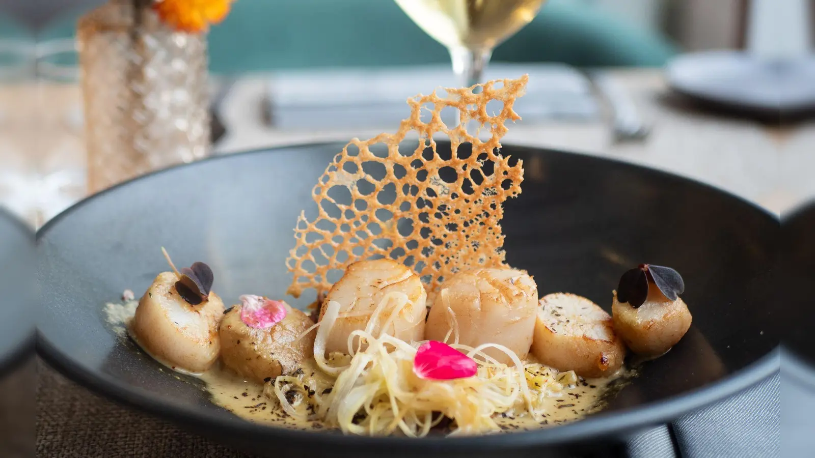 Sechs Nüsse in einer Reihe auf Lauch- und Quinoabett: So richtet Küchenchef Aurelien Leclerc seine Jakobsmuscheln an. Dazu empfiehlt er einen trockenen Weißwein. (Foto: Andreas Drouve/dpa-tmn)