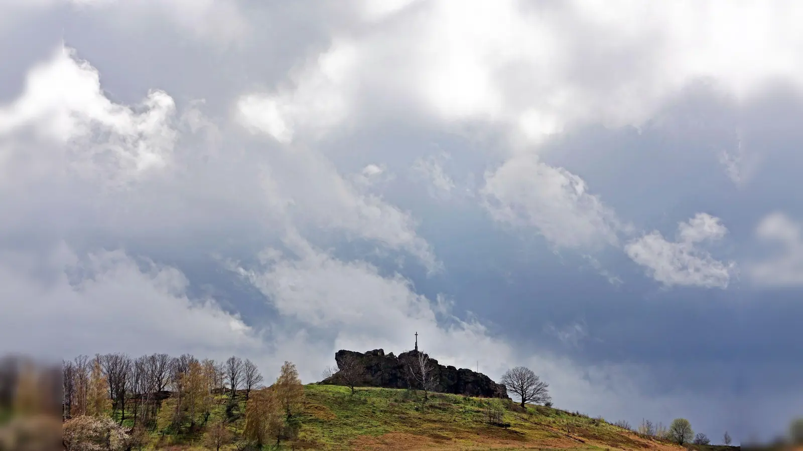 Dunkle Wolken ziehen über die Gegensteine im Harzvorland. (Foto: Matthias Bein/dpa)