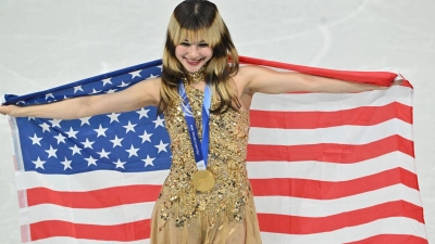 Alysa Liu bejubelt mit der US-Fahne ihre Goldmedaille. (Foto: Peter Kneffel/dpa)