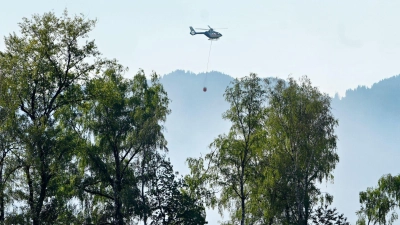 Auch mit einem Hubschrauber versuchen Einsatzkräfte die Flammen zu löschen.  (Foto: Uwe Lein/dpa)