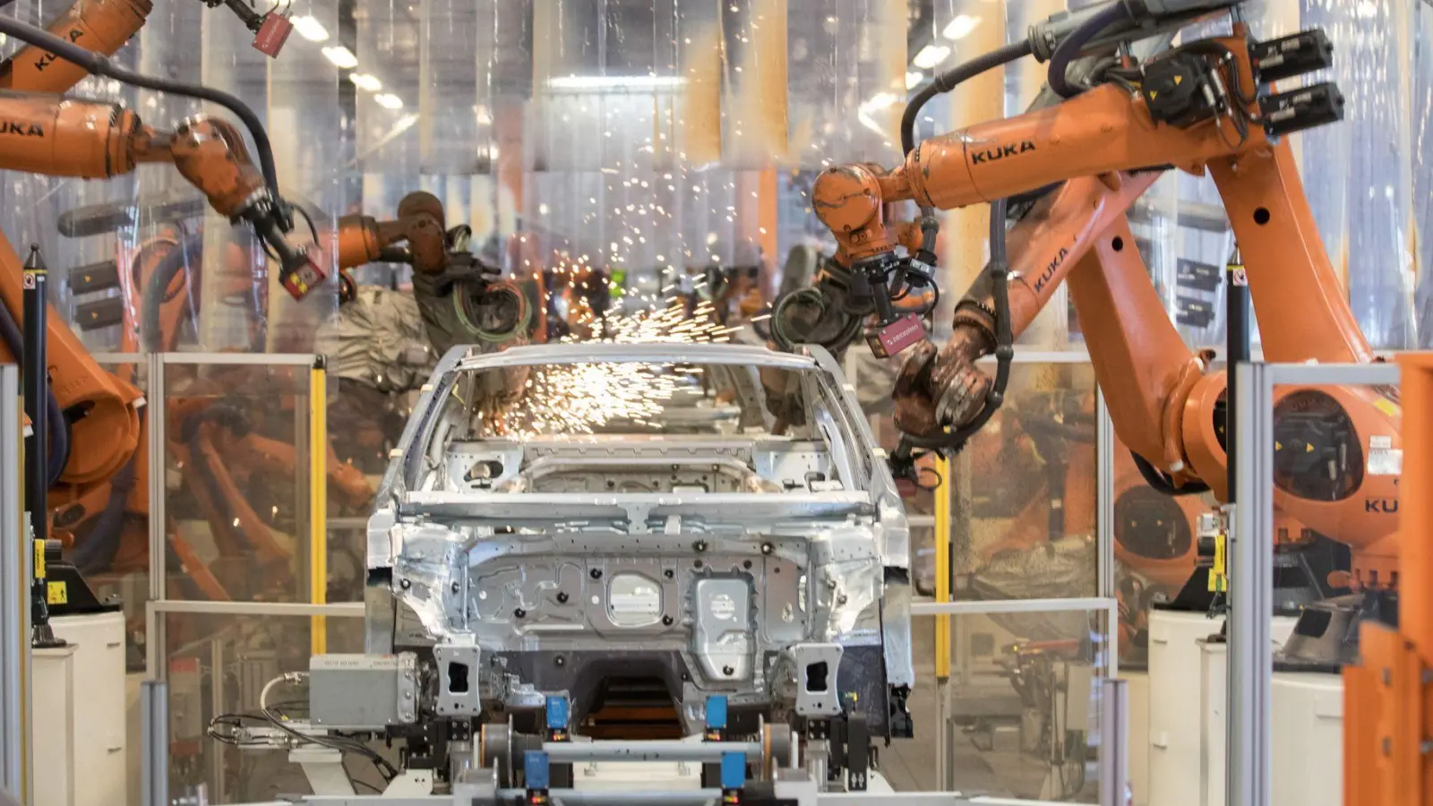 Teile eines VW Passat werden im Karosseriewerk von VW von Kuka-Robotern zusammengefügt. Der Augsburger Roboterhersteller plant den Abbau von 400 Stellen am Unternehmenssitz, insbesondere weil die Nachfrage aus der Autobranche schwach ist. (Archivbild) (Foto: Jörg Sarbach/dpa)