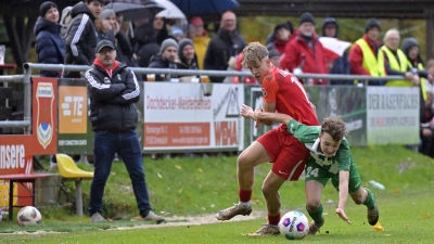 Am Ende obenauf waren die Sportfreunde Dinkelsbühl (in Rot Nico Remshard) im Derby gegen den FC/DJK Burgoberbach (in Grün Veit Eyrisch). Im Hintergrund: Sportfreunde-Trainer Fredi Skurka. (Foto: Martin Rügner)