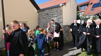 Abschied von der Pfadfindergruppe: Pfarrer Marcel Weber umringt von seiner „Affenbande“. Zuvor hat ihn Dekanin Ursula Brecht (Zweite von rechts) von seinen Aufgaben als Landpfarrer freigesprochen. (Foto: Judith Marschall)