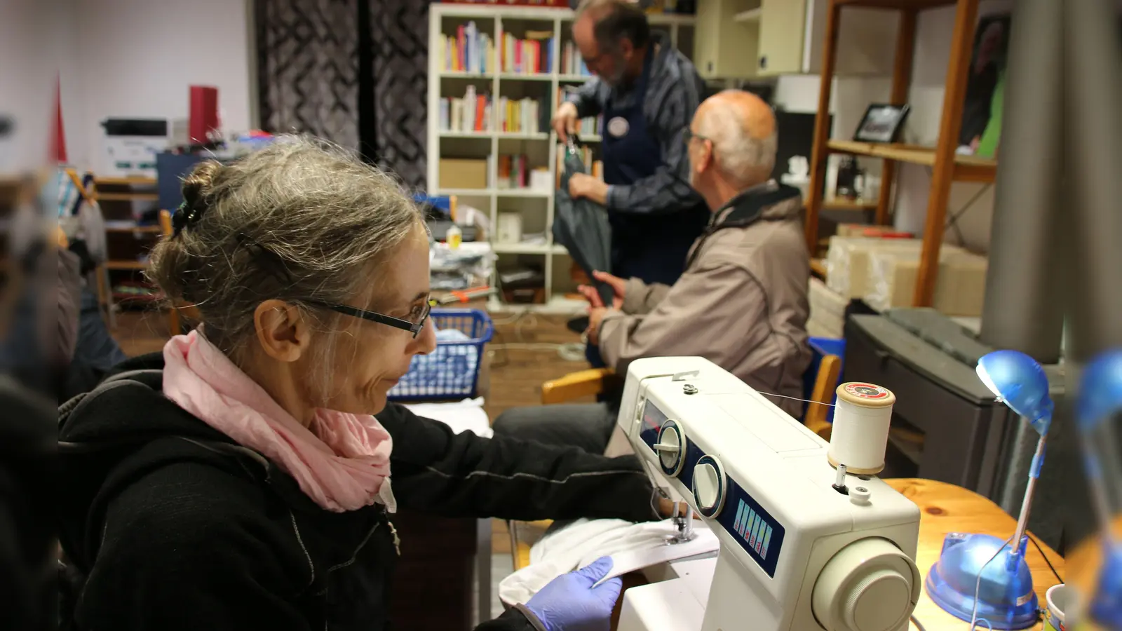 Während Iris Pfänder Kleider flickt und Nähte ausbessert, versuchen Klaus Sacher und Rainer Hesse (rechts) einen alten Regenschirm zu reparieren. (Foto: Stefan Neidl)