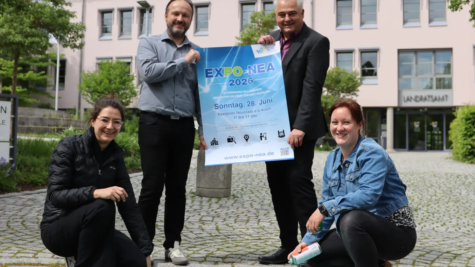 Das Team der Wirtschaftsförderung am Landratsamt, bestehend aus Julia Tschawdarow (links unten), Claus Seifert (rechts stehend), Michael Capek und Stefanie Binder, präsentiert das Plakat für die erste Neustädter Expo.  (Foto: Patrick Lauer)