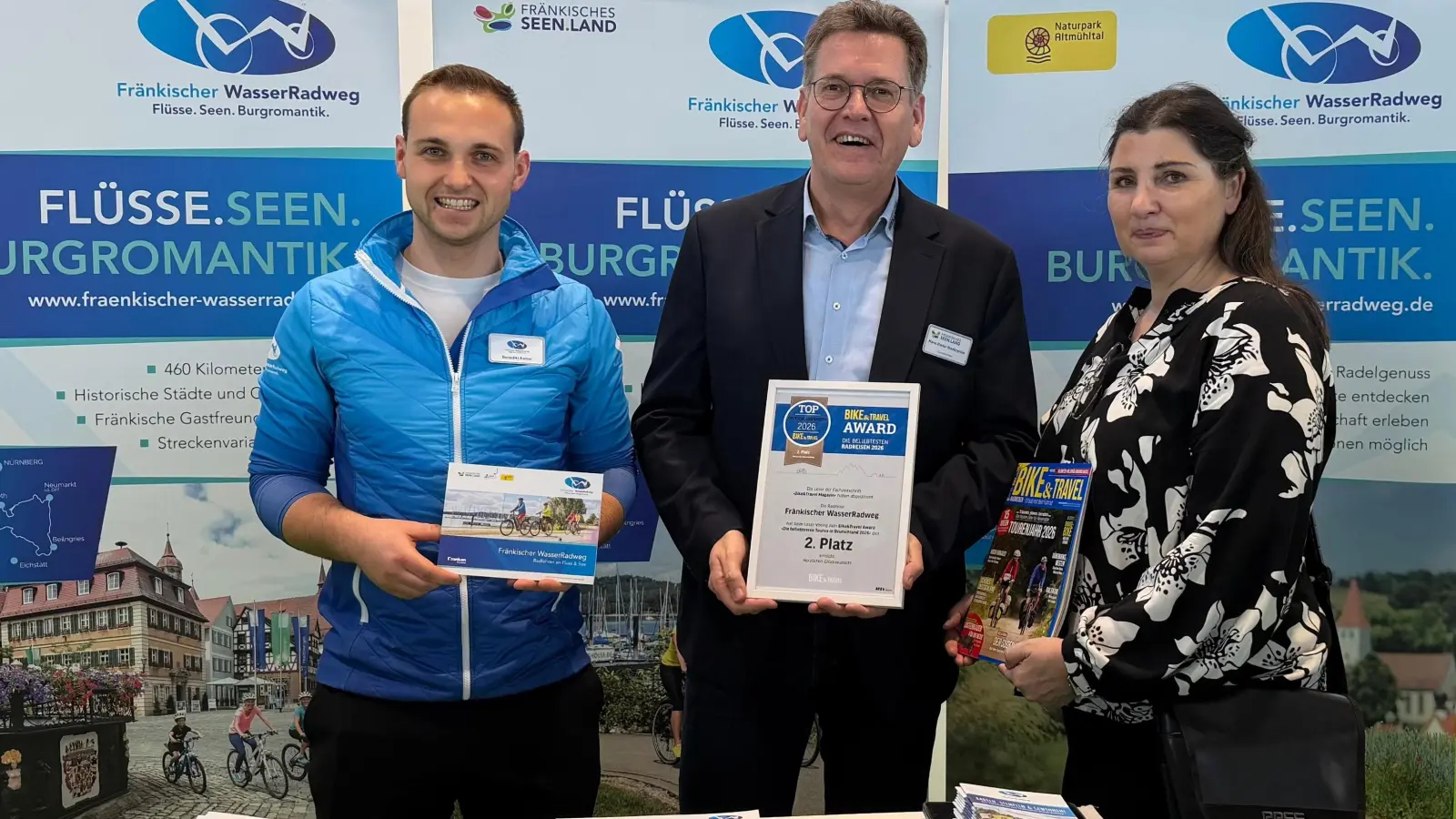 Freuten sich über die Auszeichnung: Hans-Dieter Niederprüm (Mitte), Geschäftsführer des Tourismusverbands Fränkisches Seenland und Benedikt Kamm (links), Projektmanager Fränkischer Wasserradweg, nahmen die Urkunde des „Bike &amp; Travel Award“ auf der CMT von Marion Nunn (MSV-Medien Baden-Baden) entgegen.  (Foto: AG Fränkischer WasserRadweg)