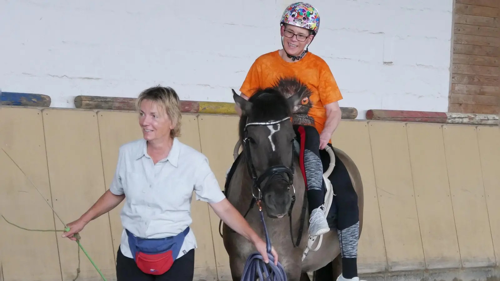 Carolin Froelich, hier zusammen mit ihrer Reitlehrerin Jutta Bauer und Astron, in einer Haltung, die sie sich selbst ausgedacht hat: Beide Beine sind auf derselben Seite des Pferderückens – eine Art Damensitz. (Foto: Ulli Ganter)