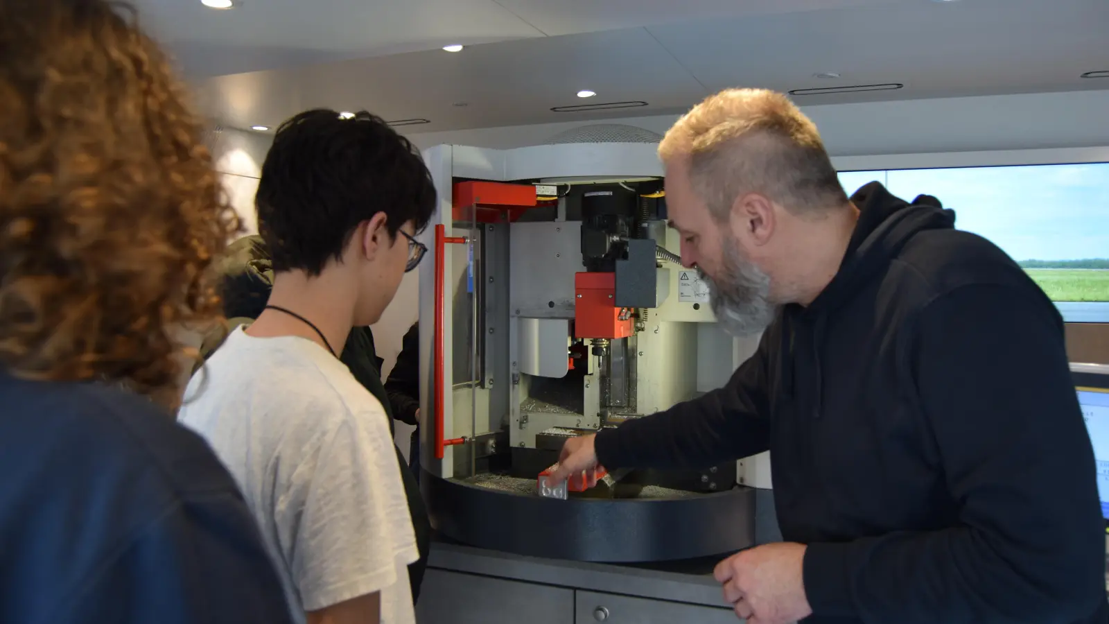 Alexander Kleic erklärte den Schülerinnen und Schülern die Prozesse an einer CNC-Fräsmaschine. (F.: Lucie Seidel)