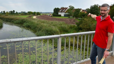 Von der Altmühlbrücke aus zeigt Jürgen Scharvogel vom Wasserwirtschaftsamt Ansbach den südlichen Deich, der zu 80 Prozent profiliert ist. (Foto: Werner Wenk)