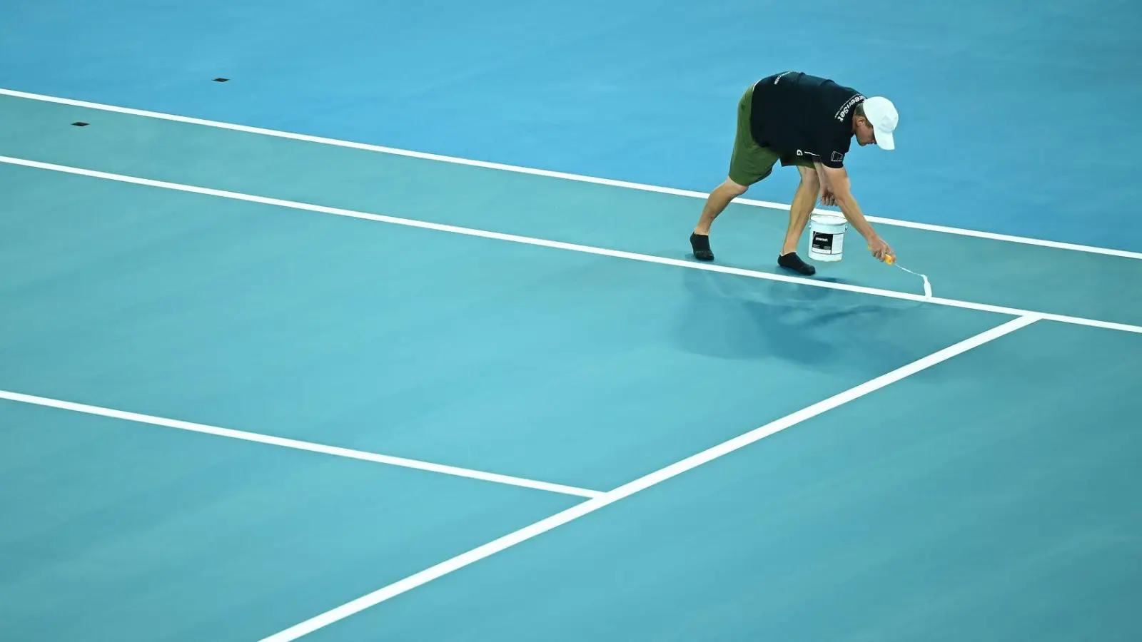 Während der Vorbereitungen für die Australian Open 2026 werden die Linien auf das Spielfeld aufgemalt. (Foto: James Ross/AAP/dpa)
