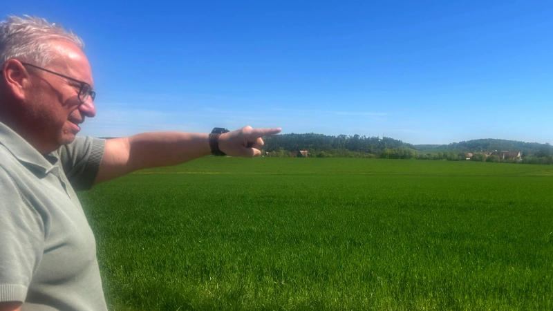 Jörg Schmitt deutet auf das rund fünf Hektar große Areal im Umgriff des Ortsteils Banzenweiler, auf dem eine industrielle Biogasanlage entstehen soll. (Foto: Florian Pöhlmann)
