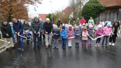 Schnipp und Schnapp, das Band ist ab: Mit Unterstützung der Kinder wurde die Windsheimer Straße in Burgbernheim offiziell wieder freigegeben. (Foto: Helmut Meixner)