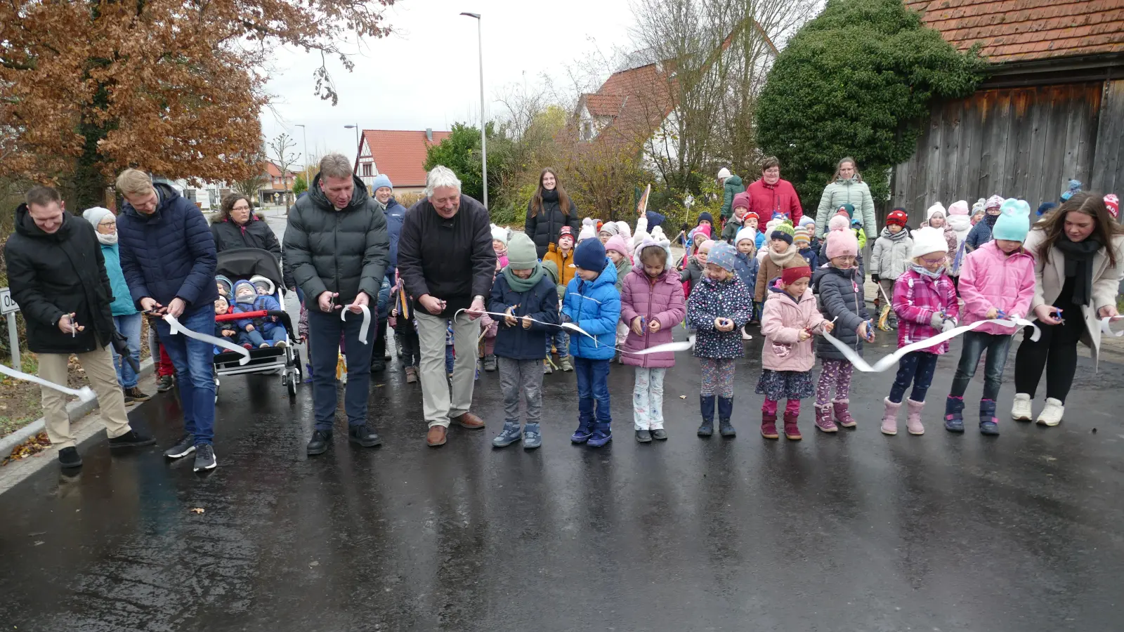 Schnipp und Schnapp, das Band ist ab: Mit Unterstützung der Kinder wurde die Windsheimer Straße in Burgbernheim offiziell wieder freigegeben. (Foto: Helmut Meixner)