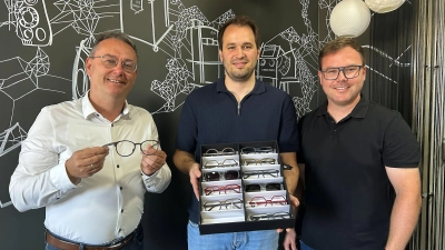 Der Vorsitzende der Lokalen Aktionsgruppe Region an der Romantischen Straße, Feuchtwangens dritter Bürgermeister Herbert Lindörfer, ließ sich von Alexander Bahle (rechts) und Tim Riedmüller (Zweiter von rechts) die Brillenkollektion zeigen.  (Foto: LAG/Julia Ploch)
