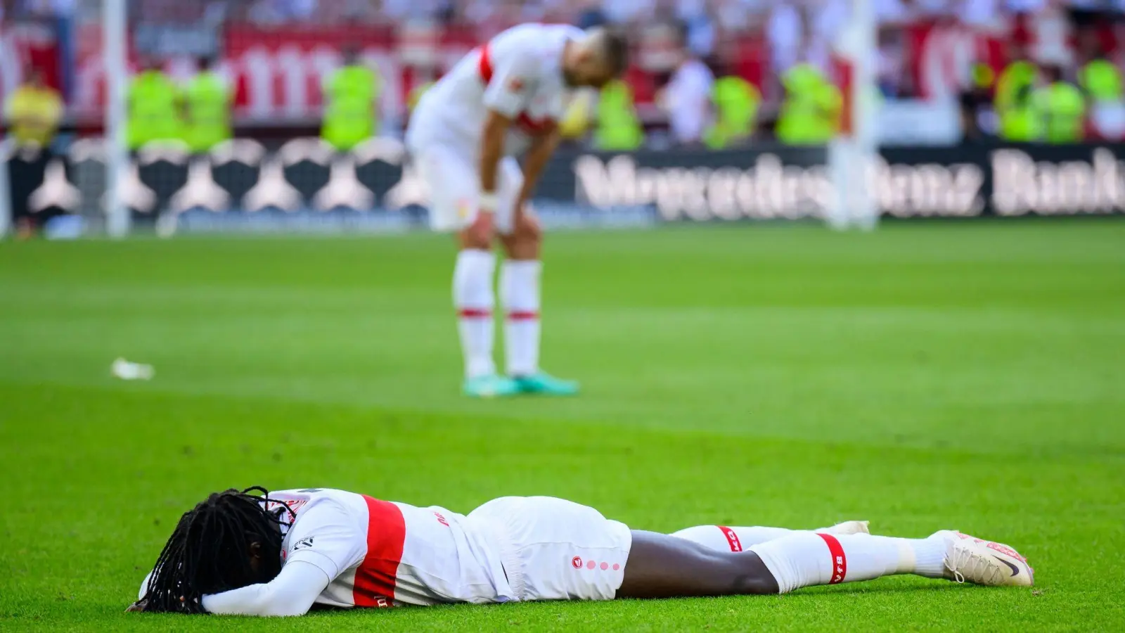 Stuttgarts Tanguy Coulibaly liegt nach dem Abpfiff enttäuscht auf dem Rasen. (Foto: Tom Weller/dpa)