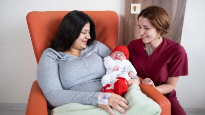 Das Weihnachtsbaby aus der Klinik Ansbach: (von links) Mutter Tountaniea Ramadan-Salich aus Feuchtwangen, Sohn Alpaslan und Hebamme Johana Watolla. (Foto: ANregiomed / Tyler Larkin)