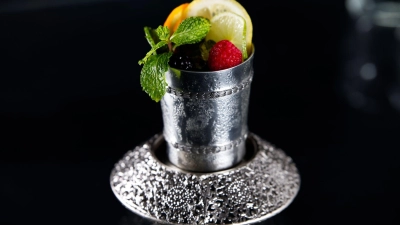 Der Cocktail Prince of Wales mit Cognac, Orangenlikör, Angostura und Champagner wird in einem Silberbecher serviert. Ersatzweise geht aber auch ein Champagnerglas. (Foto: Barschule München/dpa-tmn)