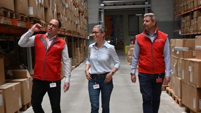 Christoph Schmitt, Kerstin Kunze und Michael Zeidler (von links) laufen durch das Lager von Loxxess in Aurach. (Foto: Anna Beigel)