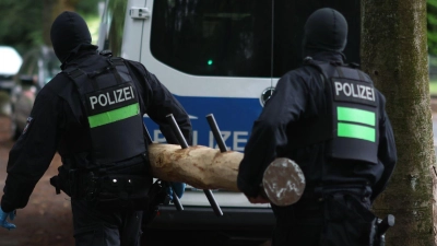 Polizisten tragen einen Rammbock. (Foto: Christoph Reichwein/dpa)