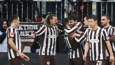 Erlösend: St. Paulis Spieler feiern das 2:0 gegen den VfB. (Foto: Christian Charisius/dpa)