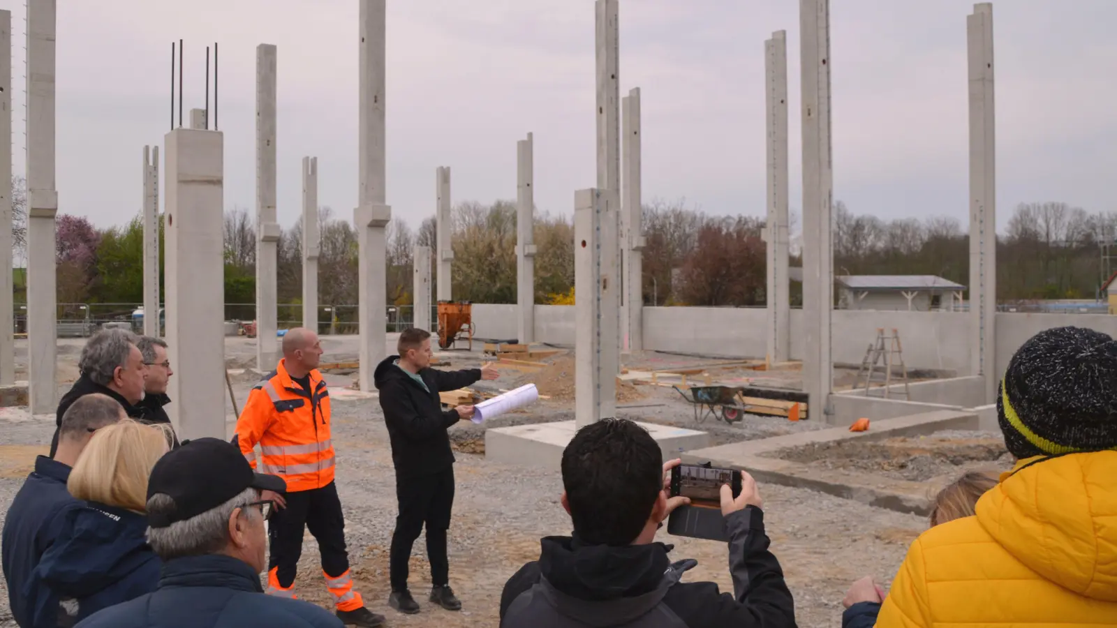 Der Leiter der Hochbauabteilung im Bauamt Viktor Scheider (vorne, mit Rolle), Bauhof-Chef Thomas Siebert (mit Warnweste) und Bürgermeister Wolfgang Lampe (links neben Siebert) führten die Uffenheimer Stadträte über die Bauhof-Baustelle an der Geckenheimer Steig. Das Fazit: Es geht gut voran. (Foto: Johannes Zimmermann)