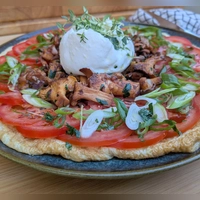 Sieht auf den ersten Blick aus wie eine Pizza, ist aber ein Omelett: Der Eierfladen wird mit Tomatenscheiben, gebratenen Pfifferlingen und Burrata belegt.  (Foto: Doreen Hassek/hauptstadtkueche.blogspot.com/dpa-tmn)