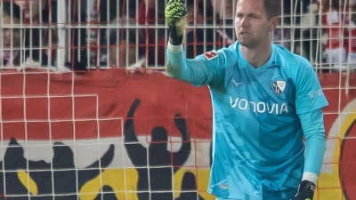 Bochums Keeper Patrick Drewes hält das Feuerzeug hoch, das ihn getroffen hat. (Foto: Andreas Gora/dpa)